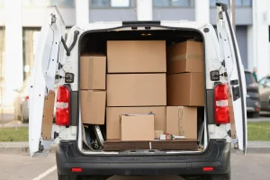 nombreuses-boites-carton-se-trouvant-dans-minibus-porte-ouverte-concept-livraison-fret-assistance-au-demenagement